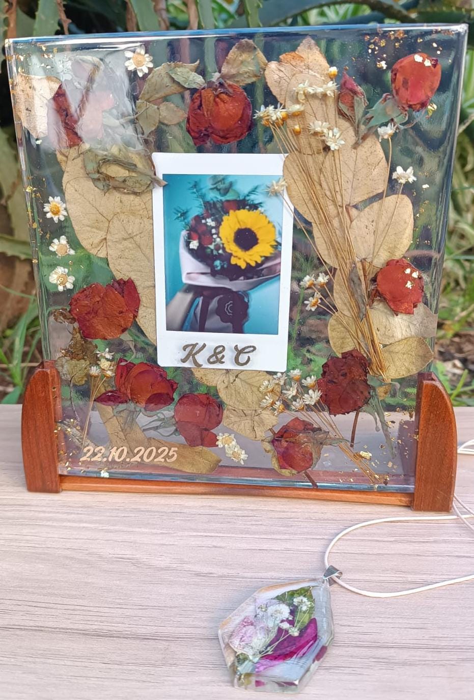 Flores e fotografia preservadas em uma peça retangular